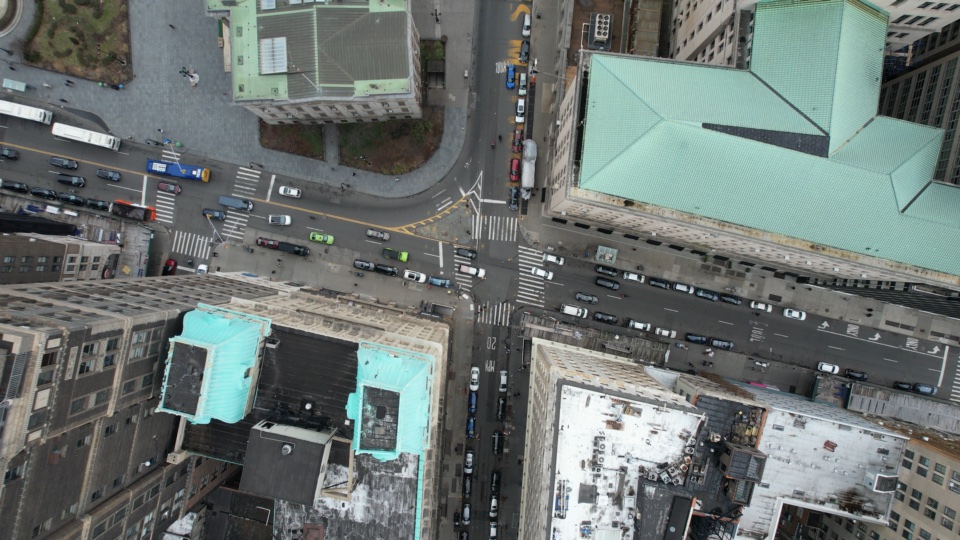 Looking straight down on a Manhattan block, traffic moving through the grid